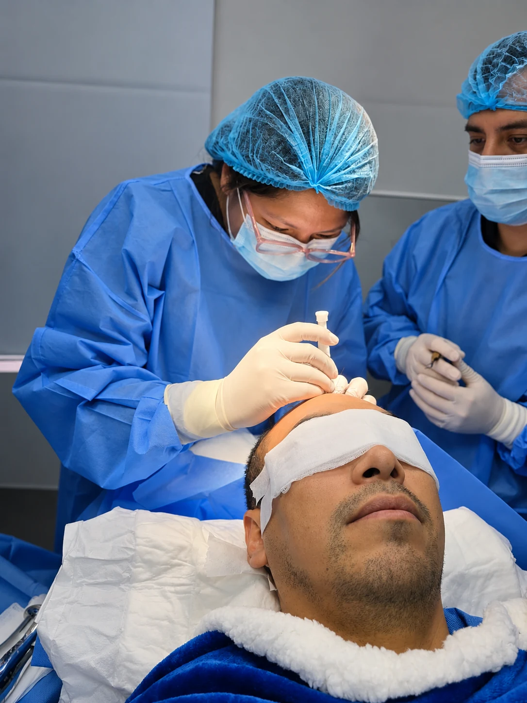 Profesionales de salud realizando un procedimiento de cirugía capilar